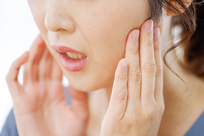 顎を押さえる女性